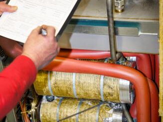 Service technician documenting maintenance and repair of a temperature control unit during service at FIMRO