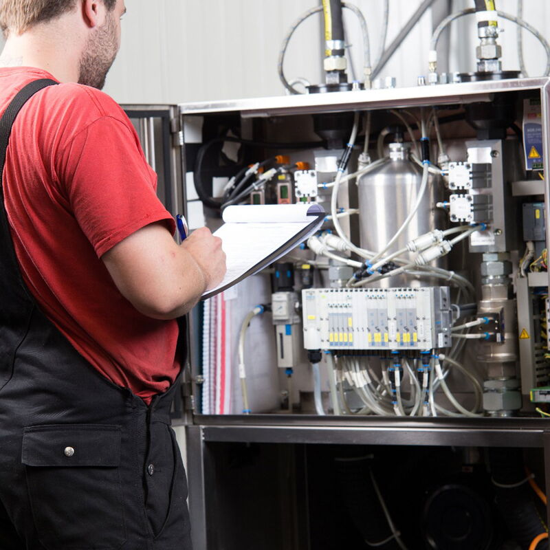 Servicetechniker dokumentiert seine Arbeiten während Wartung, Reparatur und Service an einer Vakuumanlage bei FIMRO